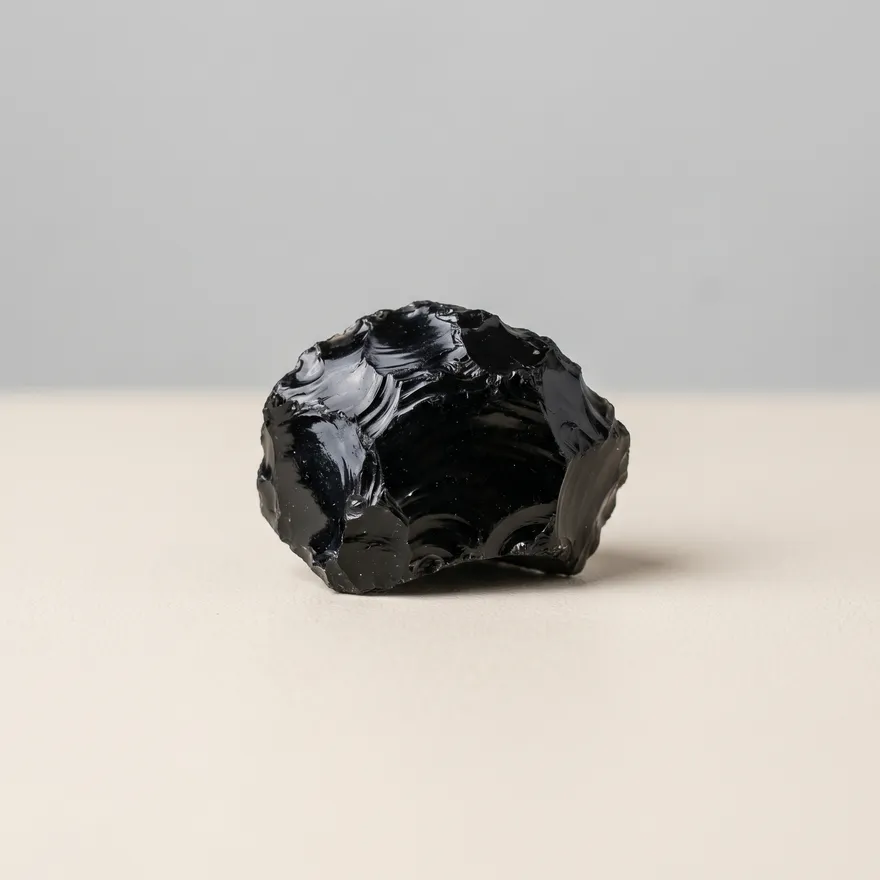 Glanzend zwarte obsidiaan met spiegelend oppervlak op een lichte achtergrond